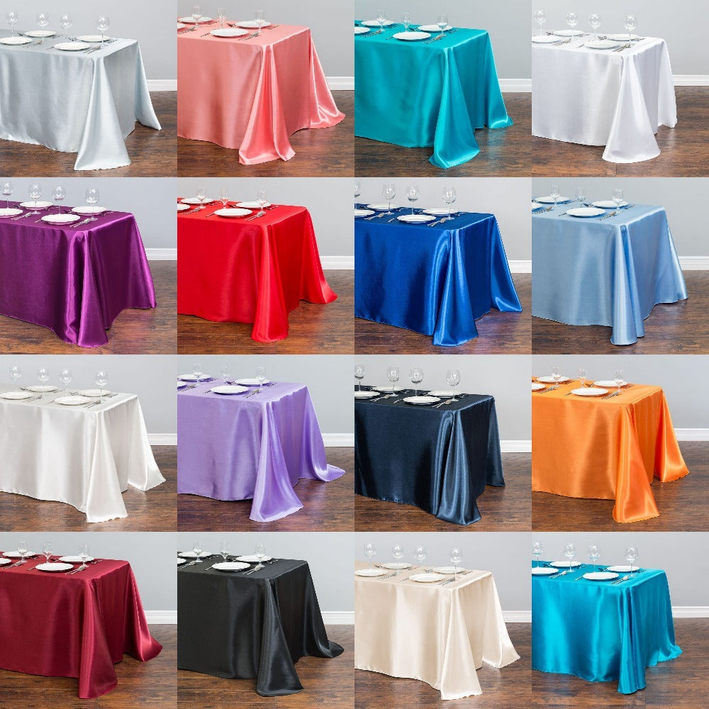 Satin table cloths in multiple colors for weddings and parties, displayed on rectangular tables.