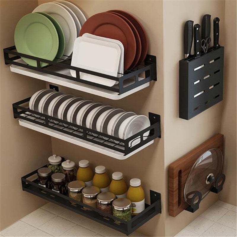 Corner kitchen organizer with black dish drain rack and knife storage, storing plates, bowls, and jars.