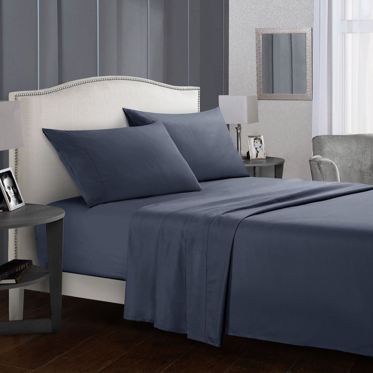 Four-piece bed sheet set on a neatly made bed in a modern bedroom.