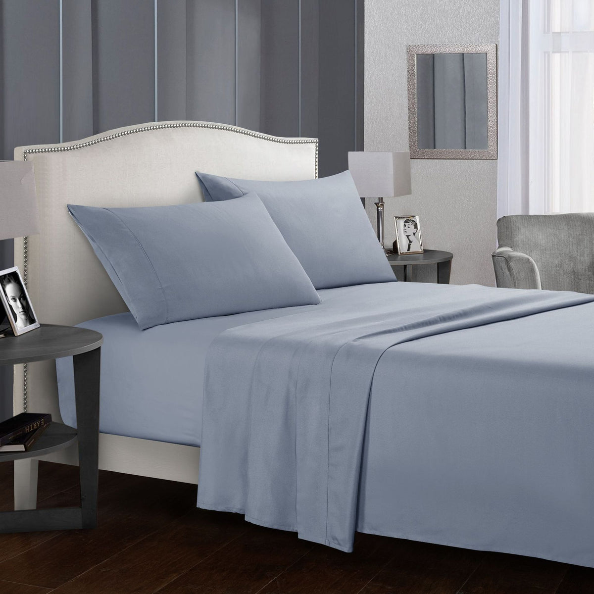 Four-piece bed sheet set on a neatly made bed with pillows in a stylish bedroom setting.