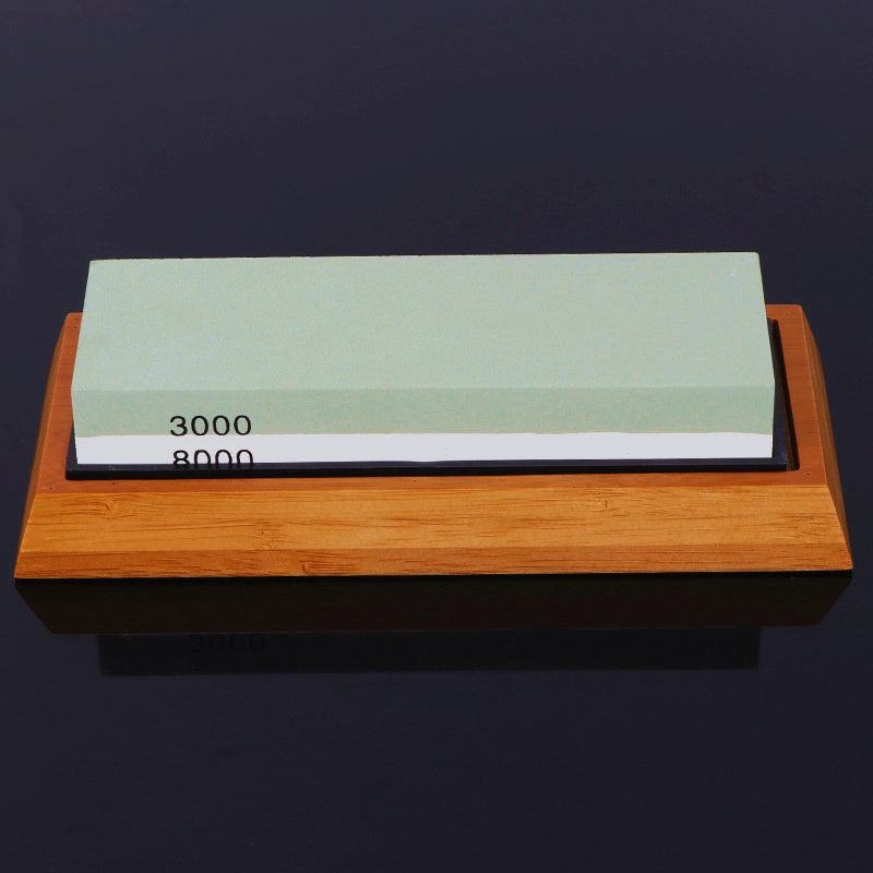 Home kitchen whetstone with bamboo base and dual grit sides.