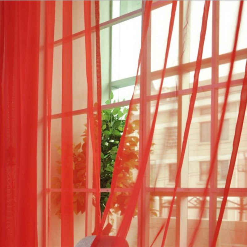 Tulle modern curtains in big red, translucent and breathable, filtering light in a living room setting.