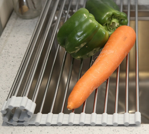 Folding kitchen drain sink rack with vegetables, stainless steel design.