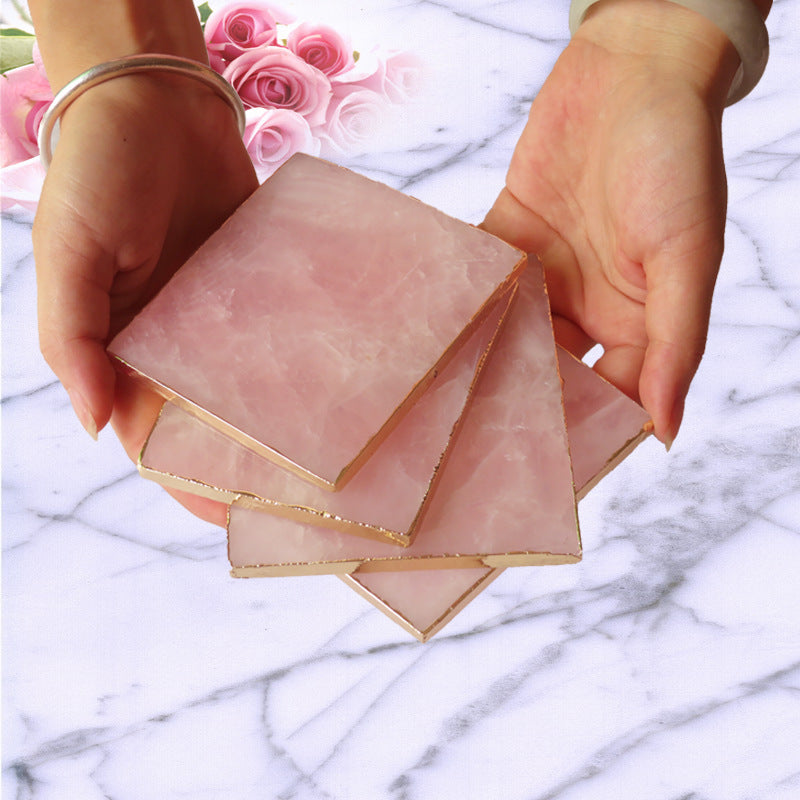 Natural hibiscus powder crystal coasters held in hands, showcasing polished surface and natural materials.
