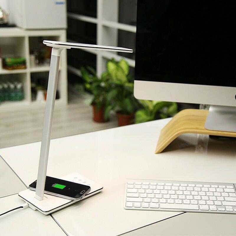 Wireless charging LED table lamp with eye protection on a desk.