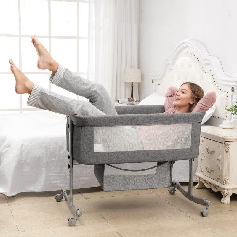 Portable baby folding cradle bed with mattress and storage basket in bedroom setting.