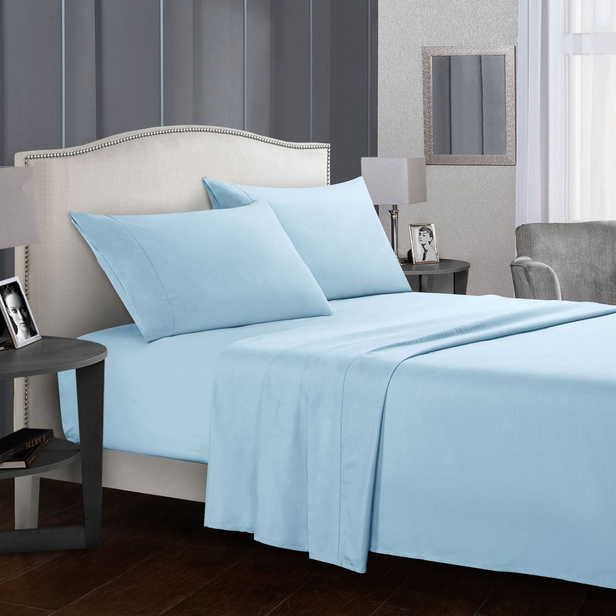 Blue four-piece bed sheet set on a neatly made bed.