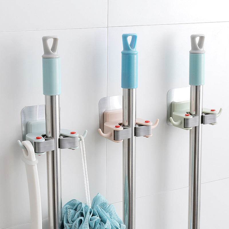 Nail-free multi-function traceless mop holder on bathroom wall holding mop and broom.