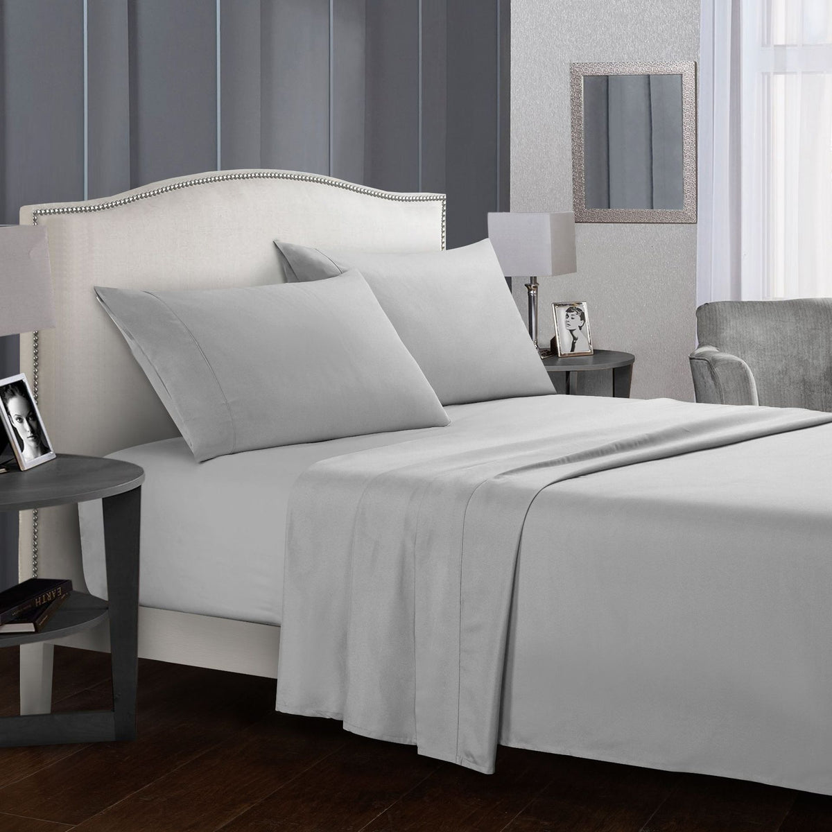 Four-piece bed sheet set on a neatly made bed in a modern bedroom.