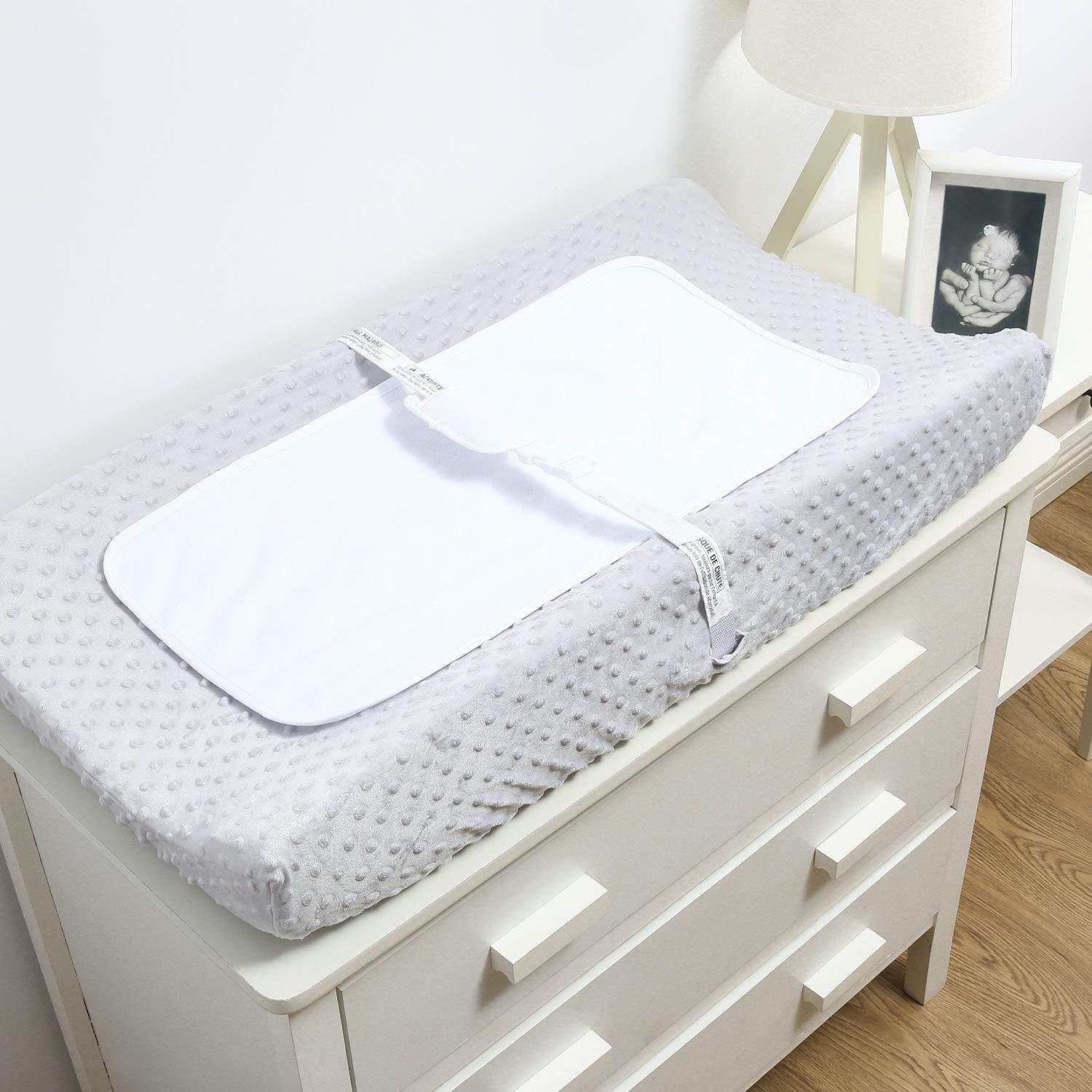 Waterproof baby nappy changing table with white minimalist design on a dresser.