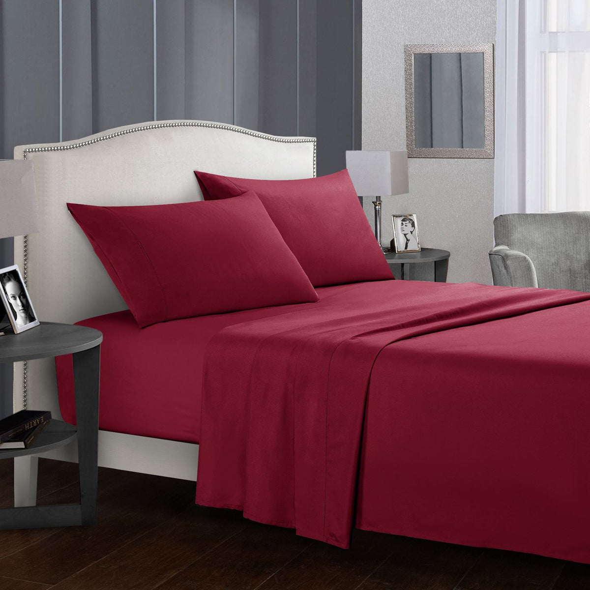 Four-piece bed sheet set in a rich burgundy color on a stylishly decorated bed.