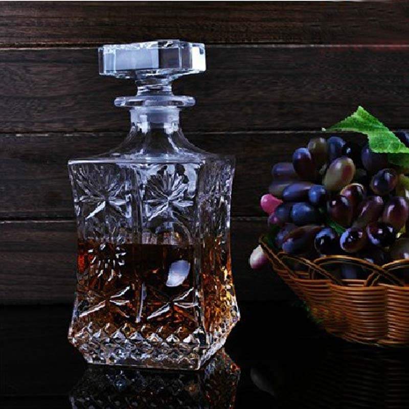 Elegant sparkling decanting wine bottle made of high white material glass, shown beside grapes.